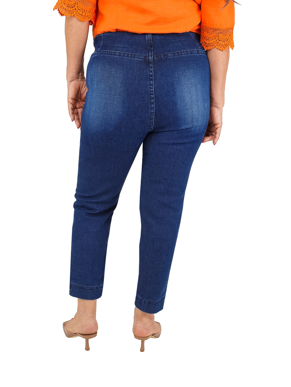 Mujer vistiendo pantalones capri de mezclilla color azul oscuro con efecto deslavado.