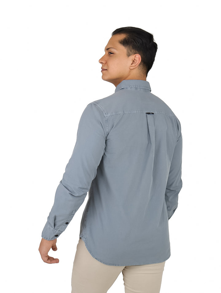 Hombre vistiendo una camisa de popelina color gris de manga larga de Calvin Klein.