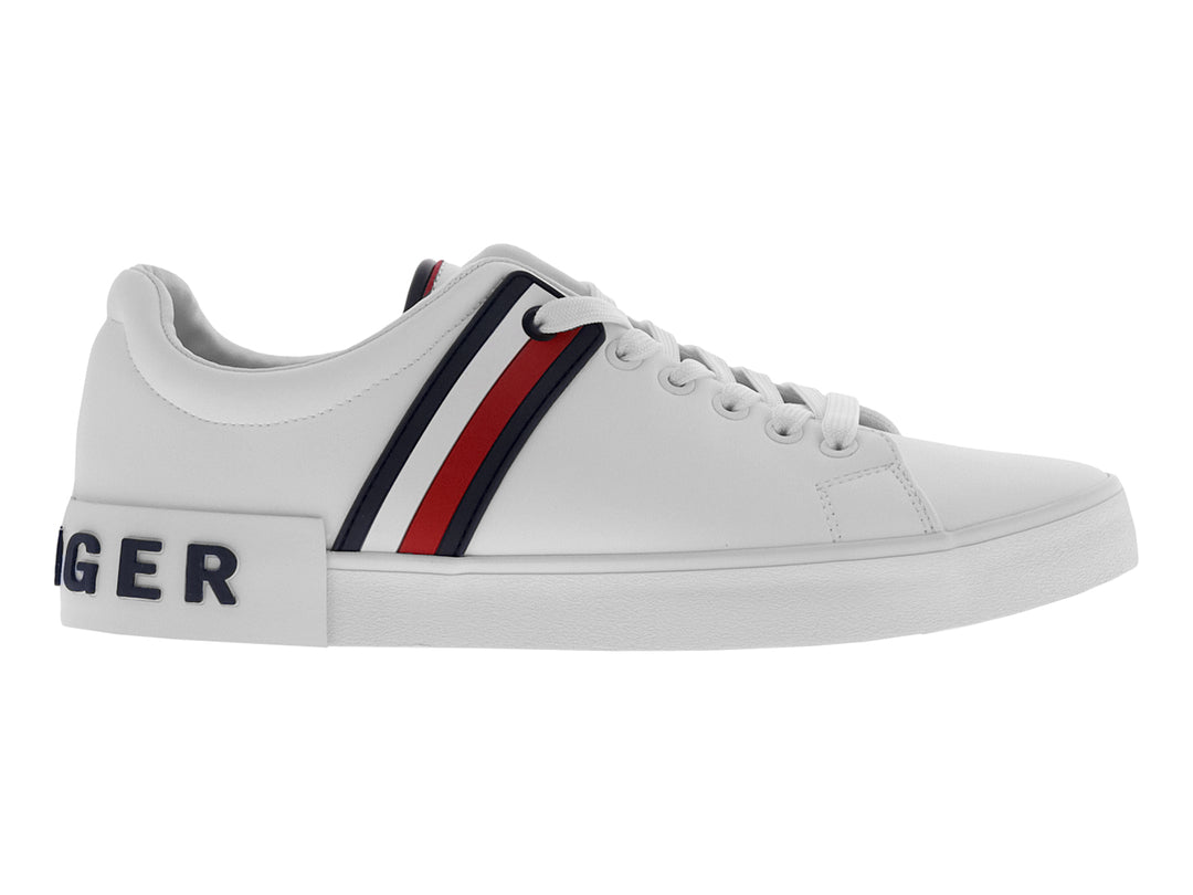 Tenis Tommy Hilfiger color blanco con franjas laterales en azul y rojo y suela blanca.