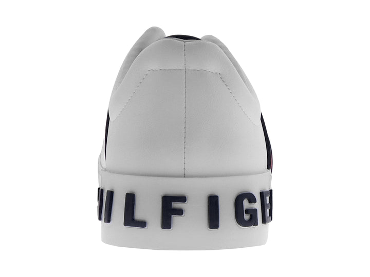 Tenis Tommy Hilfiger color blanco con franjas laterales en azul y rojo y suela blanca.