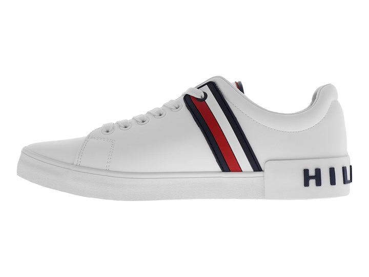 Tenis Tommy Hilfiger color blanco con franjas laterales en azul y rojo y suela blanca.