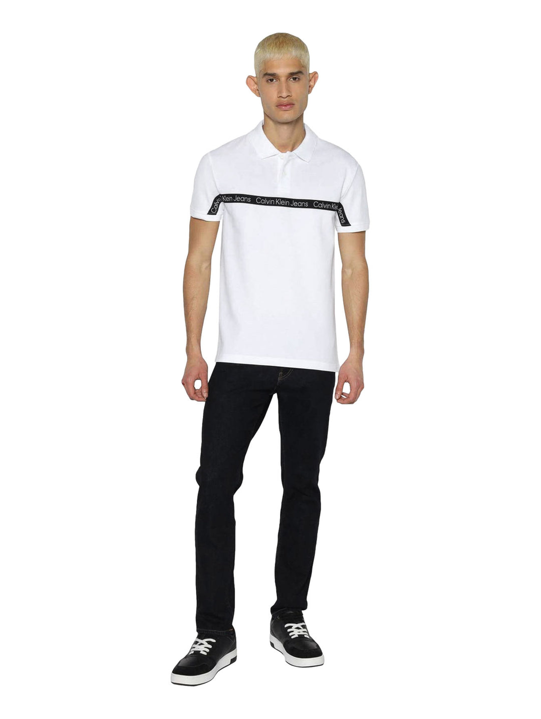 Hombre vistiendo polo blanco de Calvin Klein con cinta negra con logo en el pecho.
