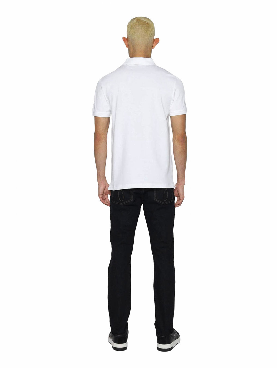 Hombre vistiendo polo blanco de Calvin Klein con cinta negra con logo en el pecho.