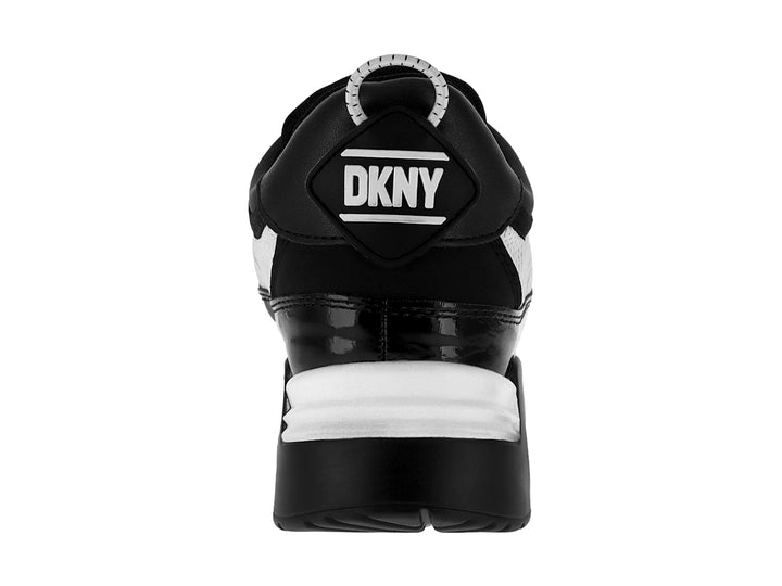 Tenis DKNY color blanco y negro con correa ajustable y suela con amortiguación.