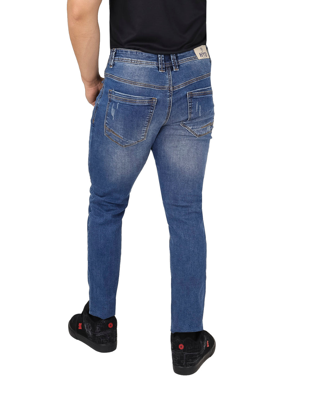 Hombre usando pantalones jeans color azul con efecto de desgaste y destrucción.
