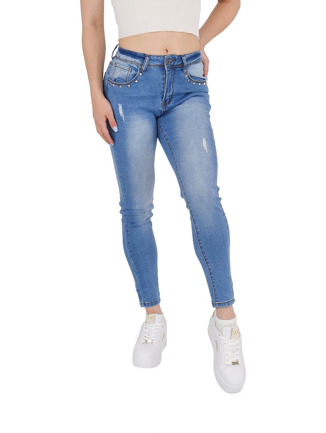 Jeans ajustados color azul con estoperoles en los bolsillos y detalles de desgaste.