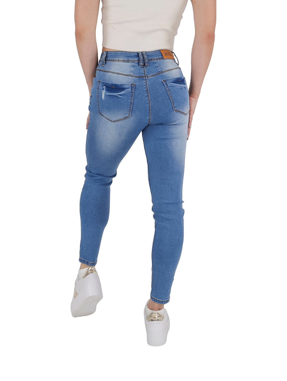 Jeans ajustados color azul con estoperoles en los bolsillos y detalles de desgaste.