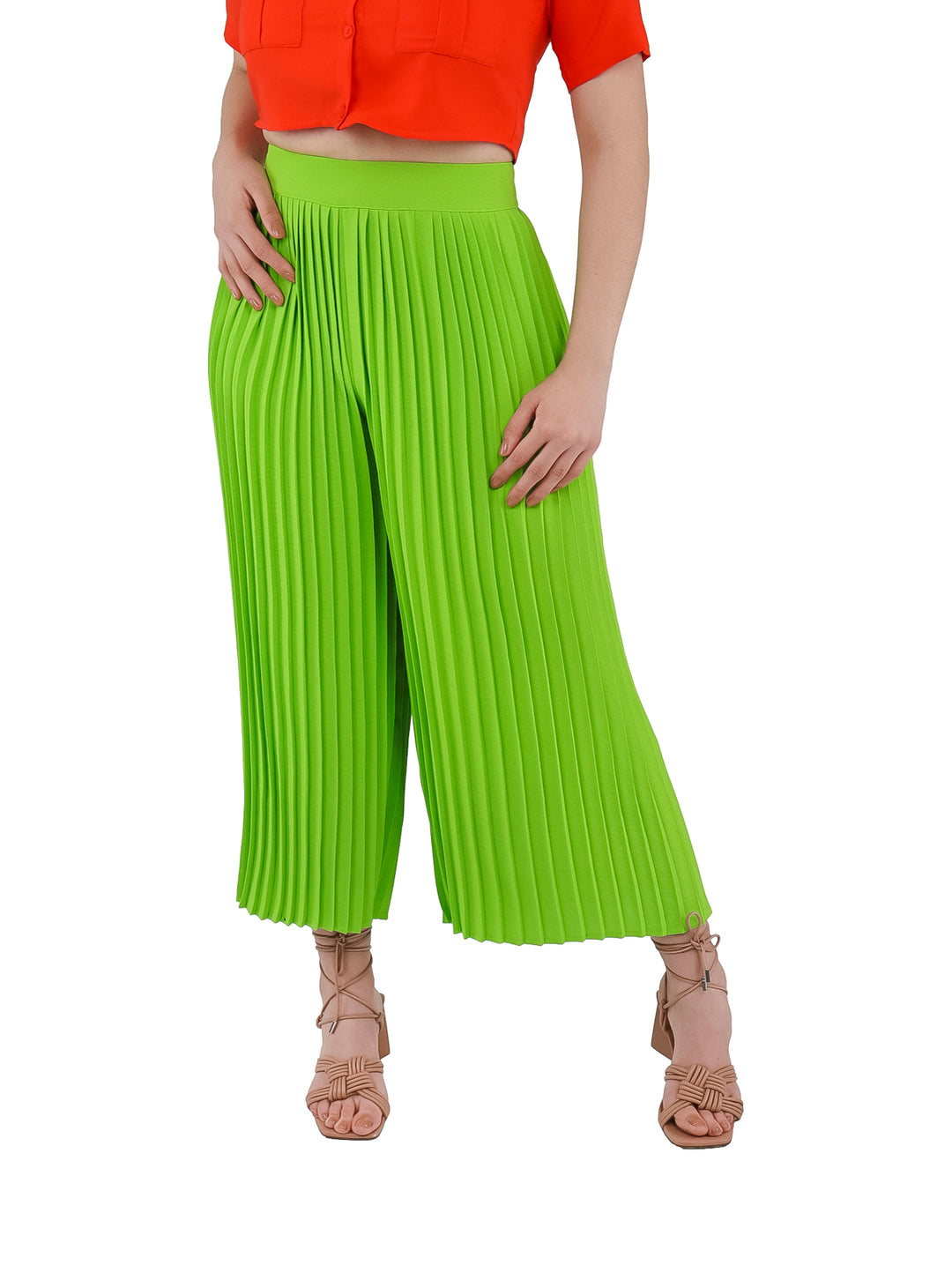 Mujer vistiendo pantalón plisado de color lima con corte ancho y cintura alta.