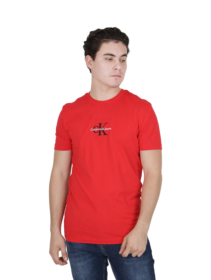 Hombre vistiendo camiseta roja de manga corta Calvin Klein con logotipo negro en el pecho.