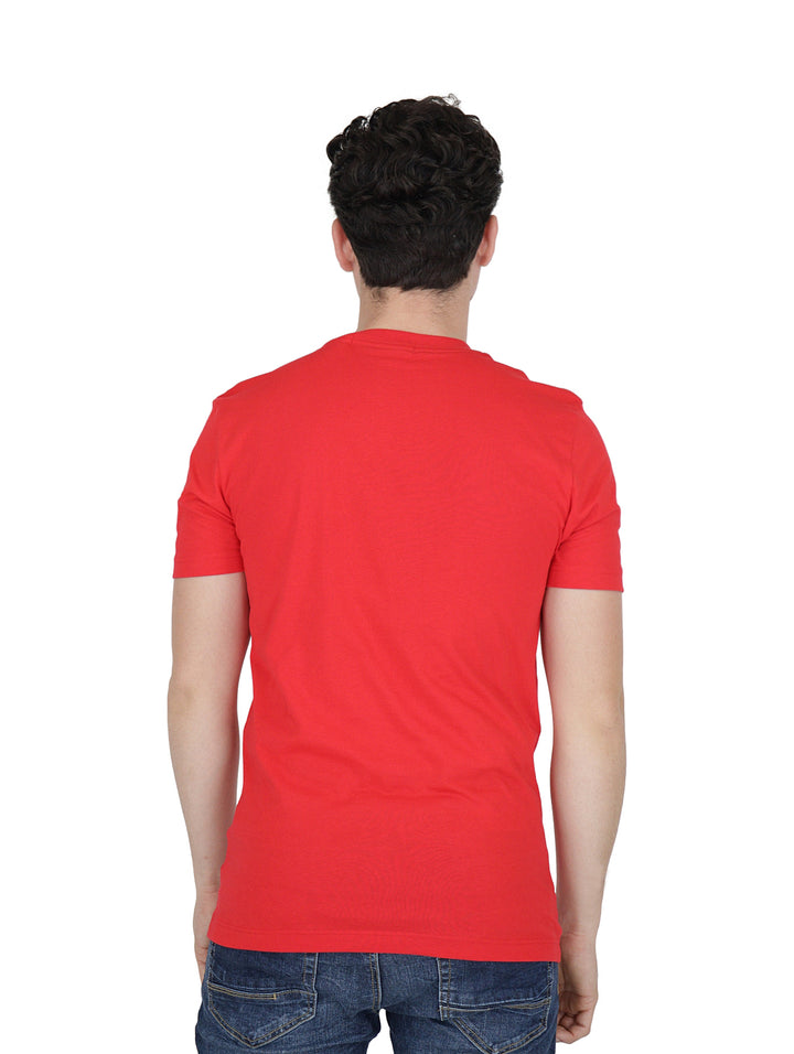 Hombre vistiendo camiseta roja de manga corta Calvin Klein con logotipo negro en el pecho.