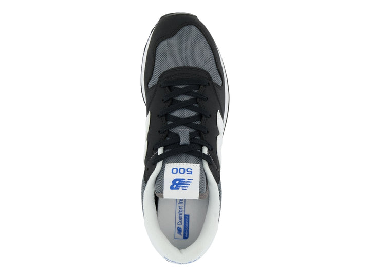 Tenis New Balance color negro con suela blanca y detalles en gris, vista lateral.