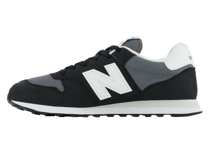 Tenis New Balance color negro con suela blanca y detalles en gris, vista lateral.