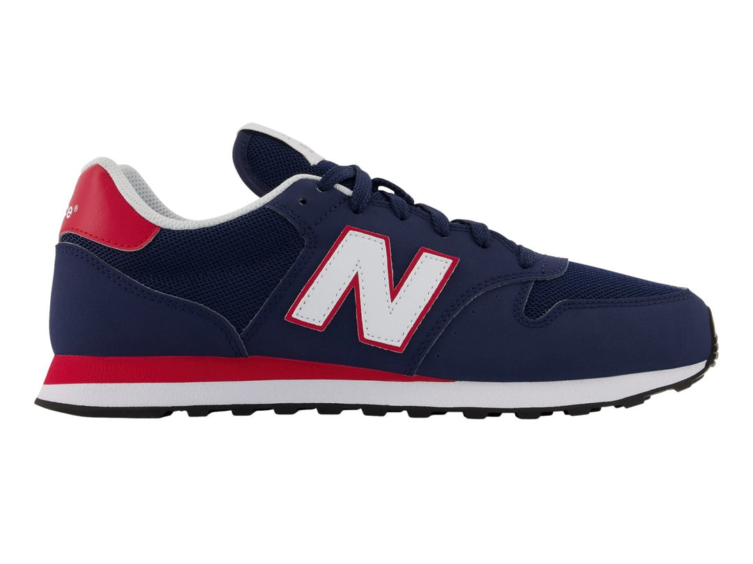 Tenis New Balance color azul marino con detalles en blanco y rojo y suela blanca.