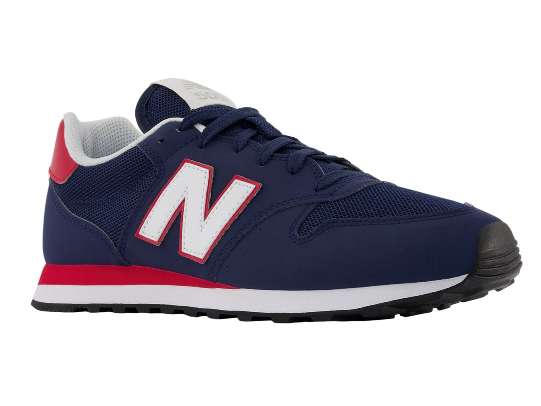 Tenis New Balance color azul marino con detalles en blanco y rojo y suela blanca.