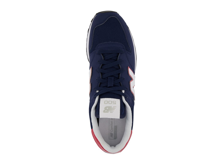 Tenis New Balance color azul marino con detalles en blanco y rojo y suela blanca.