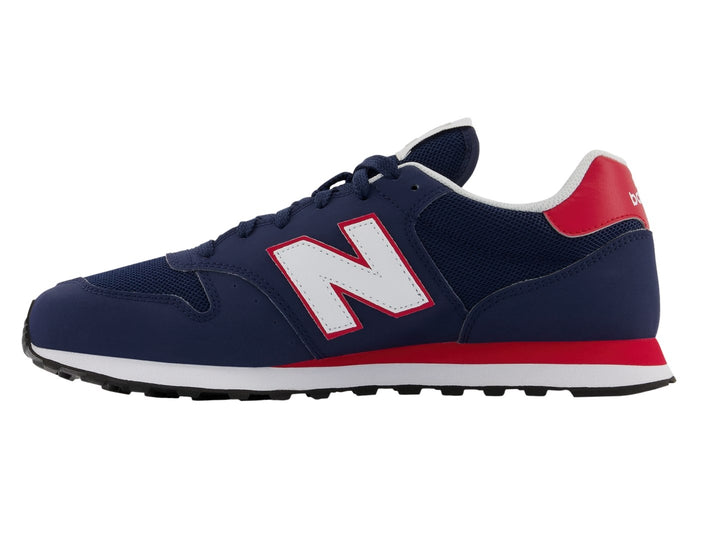 Tenis New Balance color azul marino con detalles en blanco y rojo y suela blanca.