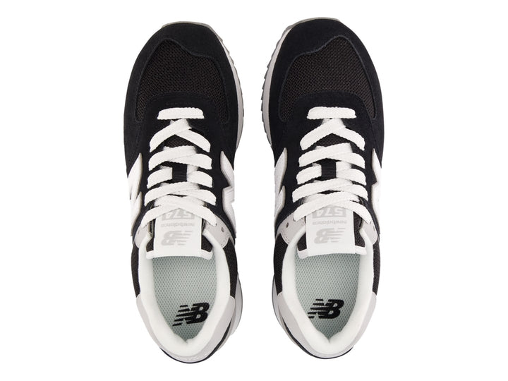 Tenis New Balance negros con suela de plataforma blanca y detalles en gris.