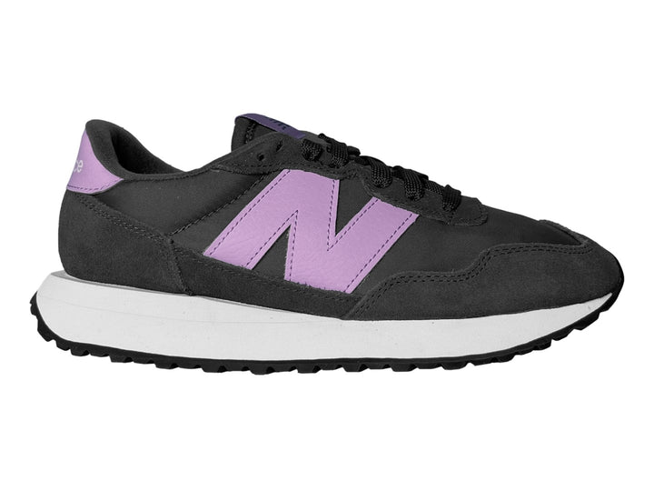 Tenis New Balance color negro con suela blanca y logotipo en color morado.