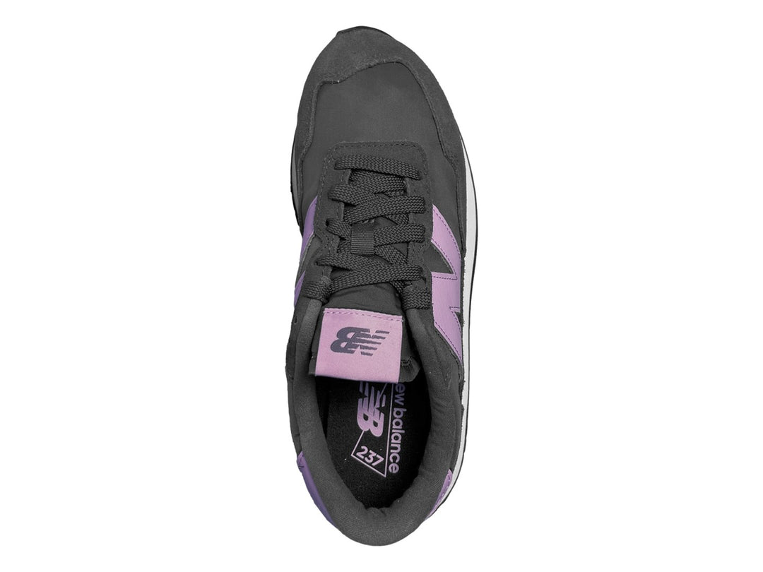 Tenis New Balance color negro con suela blanca y logotipo en color morado.
