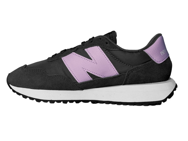 Tenis New Balance color negro con suela blanca y logotipo en color morado.