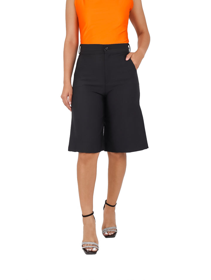 Mujer vistiendo un short amplio de color negro con talle alto y corte recto.
