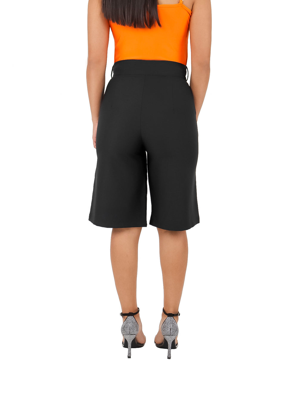Mujer vistiendo un short amplio de color negro con talle alto y corte recto.