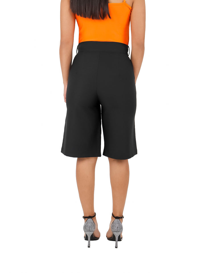 Mujer vistiendo un short amplio de color negro con talle alto y corte recto.