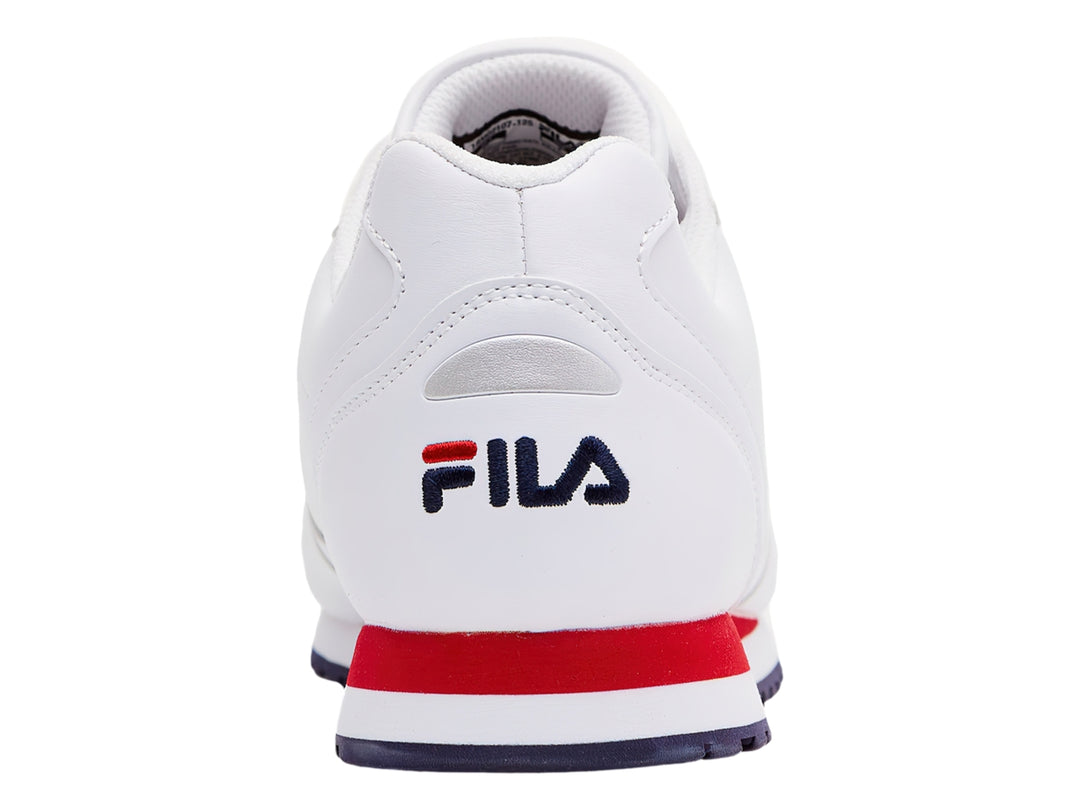 Tenis FILA Memento blancos con franja roja lateral y suela azul marino.