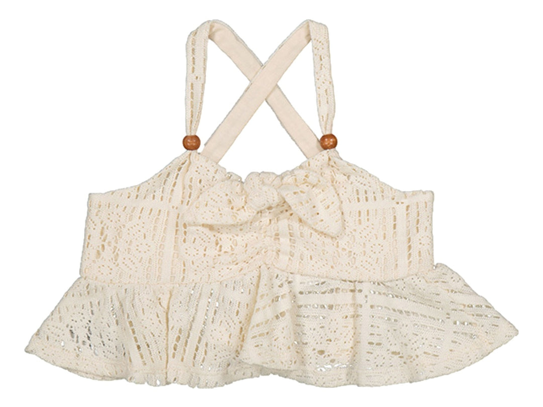 Top beige de tejido calado con tirantes cruzados, nudo frontal y volante inferior.