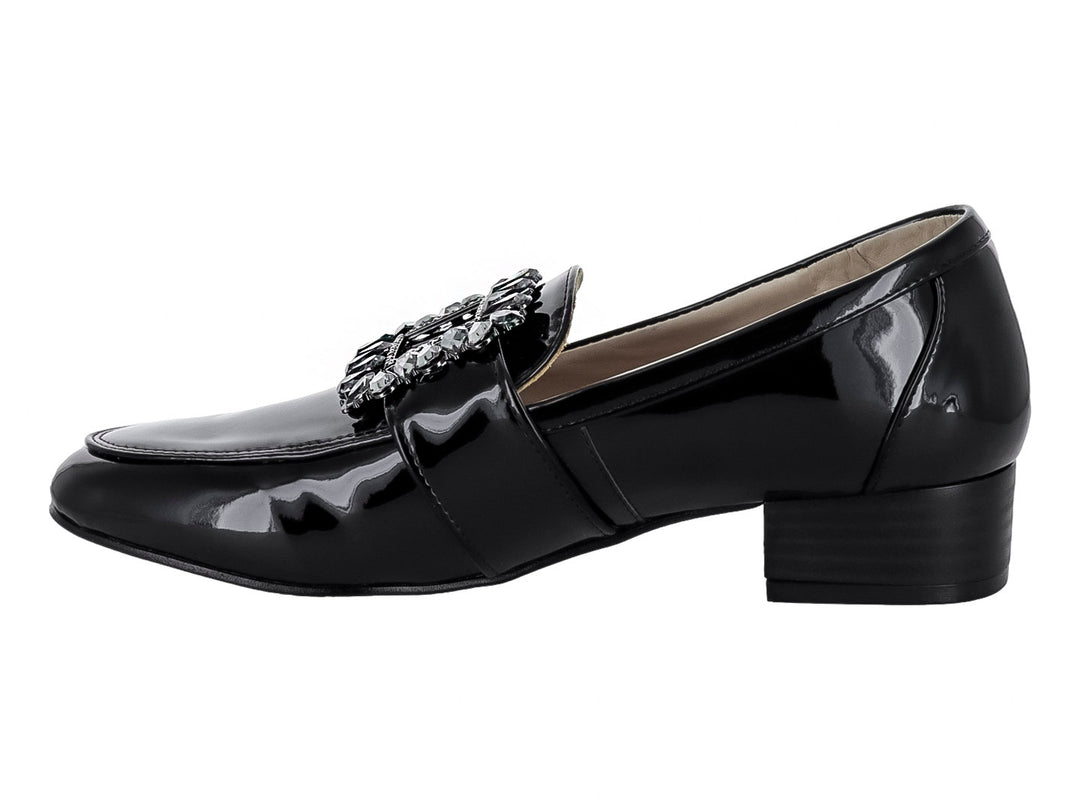 Zapato mocasín de charol negro con hebilla decorativa de cristales y tacón cuadrado.