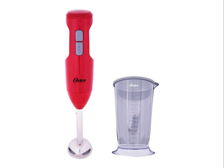 Batidora de inmersión Oster de color rojo con vaso medidor transparente sobre fondo blanco.