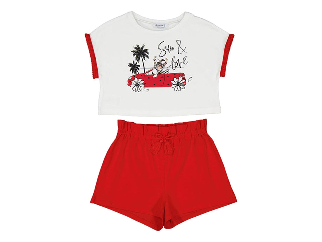 Conjunto infantil de camiseta blanca con estampado y shorts rojos.