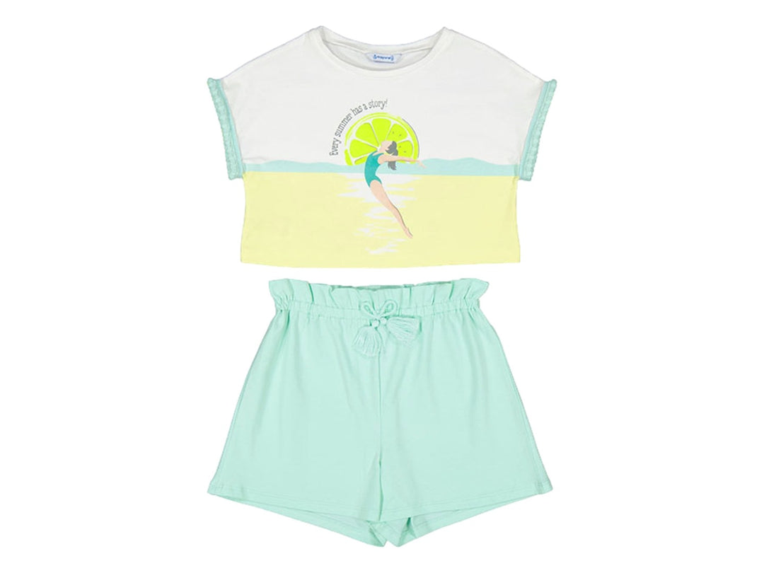 Conjunto de ropa infantil Mayoral con camiseta blanca y amarilla estampada y shorts color aguamarina.