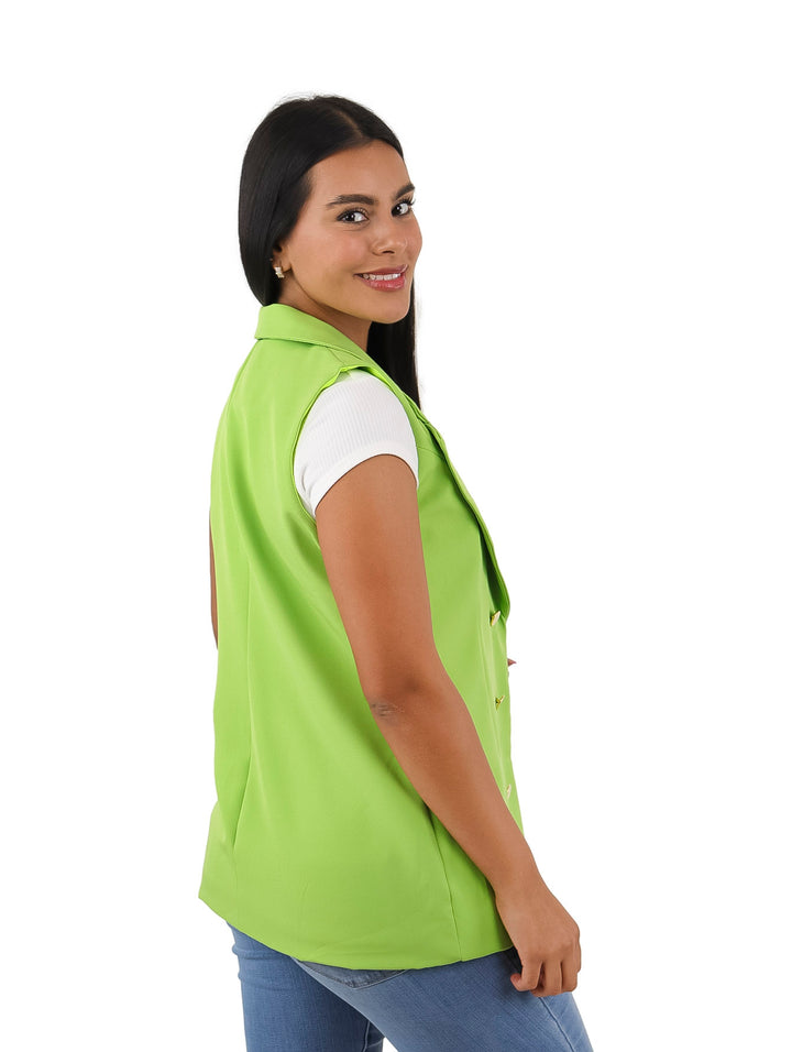 Mujer vistiendo un chaleco largo color verde kiwi con botones dorados.