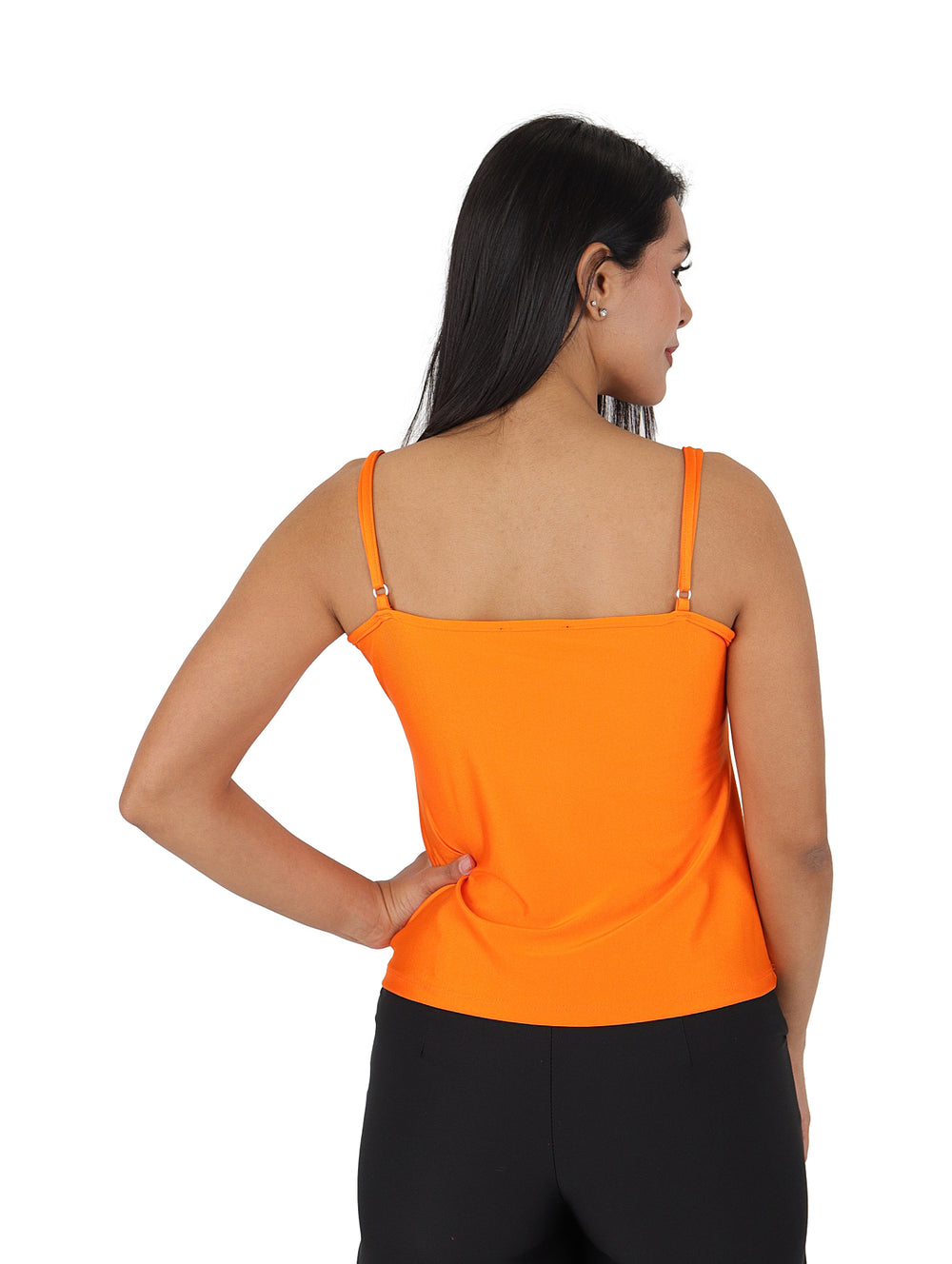 Mujer vistiendo una blusa naranja de tirantes con cuello drapeado y pantalones negros.