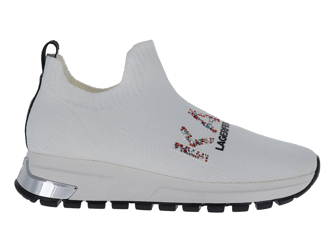Tenis slip-on blancos de tela con suela negra y detalles de marca coloridos.