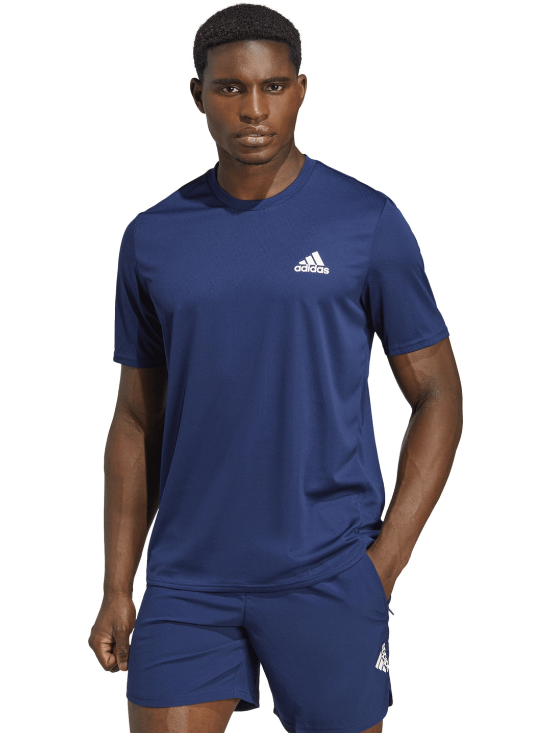 Hombre vistiendo camiseta y shorts deportivos Adidas en color azul royal.