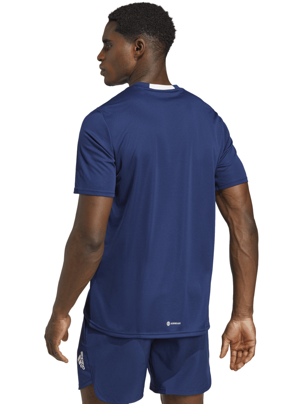 Hombre vistiendo camiseta y shorts deportivos Adidas en color azul royal.
