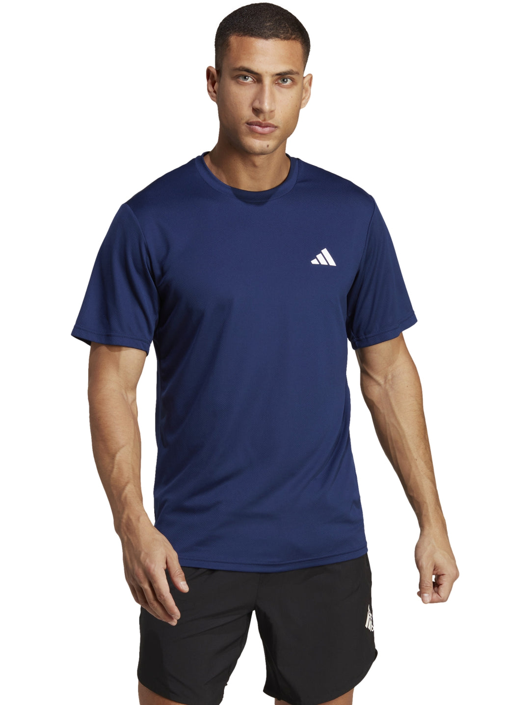 Hombre vistiendo una playera deportiva Adidas de color azul con logo blanco en el pecho.