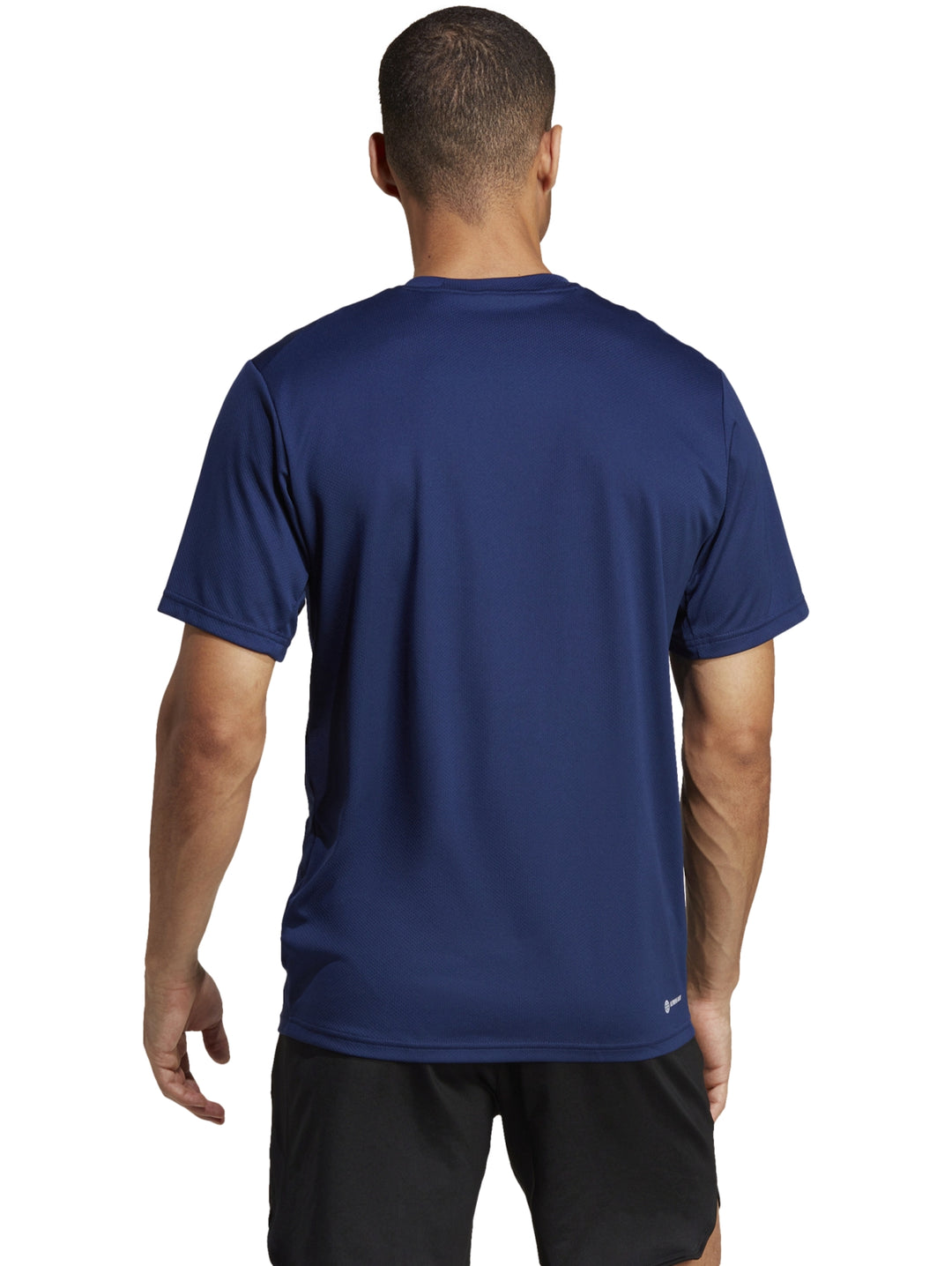 Hombre vistiendo una playera deportiva Adidas de color azul con logo blanco en el pecho.