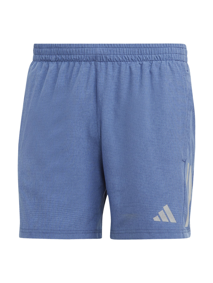 Hombre vistiendo shorts deportivos Adidas de color azul con tenis blancos.
