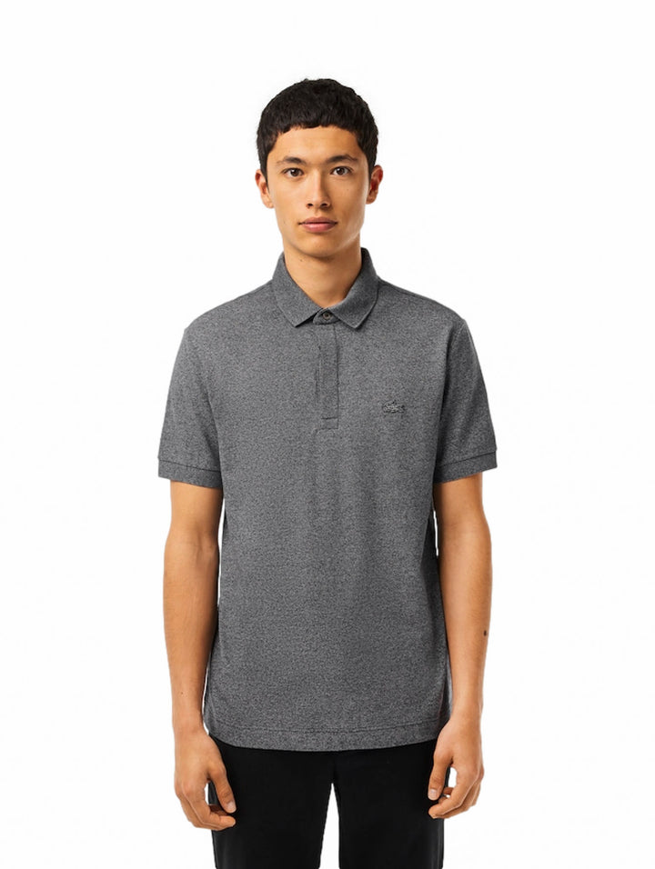 Hombre vistiendo una camiseta polo de manga corta color gris jaspeado con cuello acanalado.