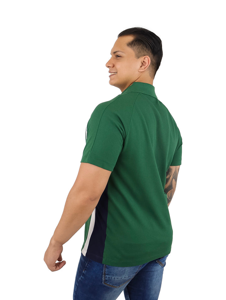 Hombre vistiendo una playera polo Lacoste color verde con franjas laterales blancas y azul marino.