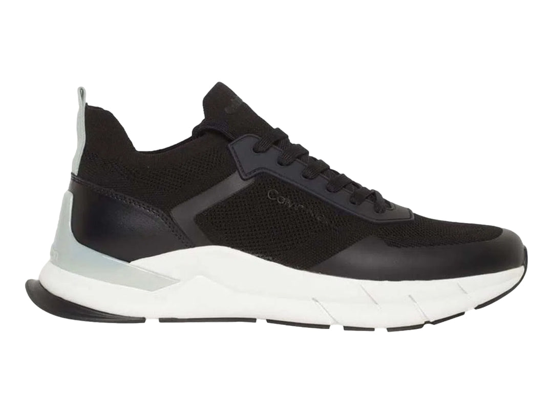 Tenis Calvin Klein negros con suela blanca y detalles en tejido.