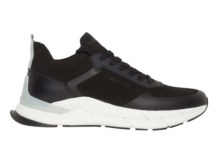 Tenis Calvin Klein negros con suela blanca y detalles en tejido.