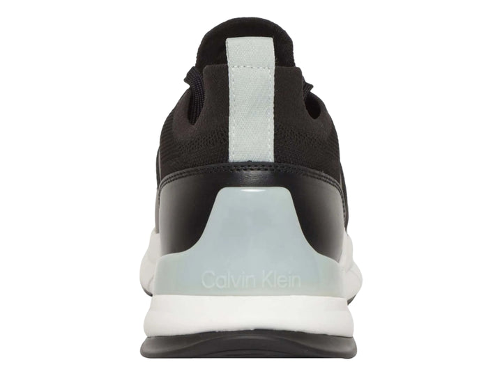 Tenis Calvin Klein negros con suela blanca y detalles en tejido.