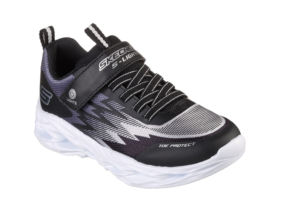 Tenis deportivos Skechers para Niño en color negro y gris con suela blanca gruesa y detalles azules.