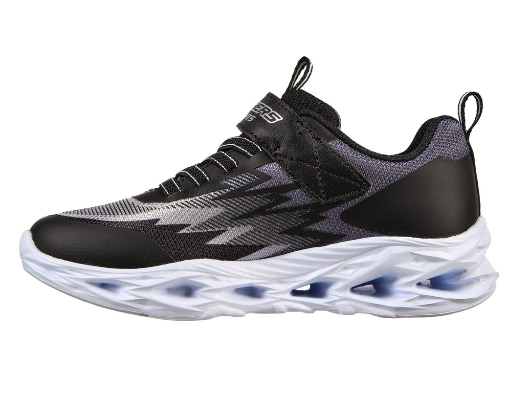 Tenis deportivos Skechers para Niño en color negro y gris con suela blanca gruesa y detalles azules.