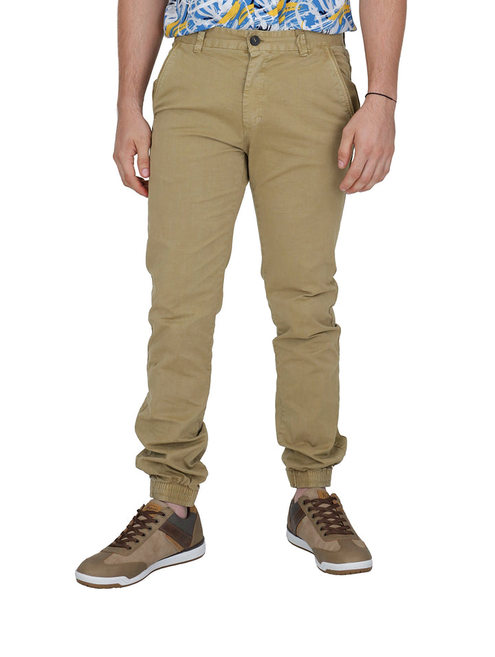 Hombre vistiendo pantalones tipo jogger color beige y calzado casual café.