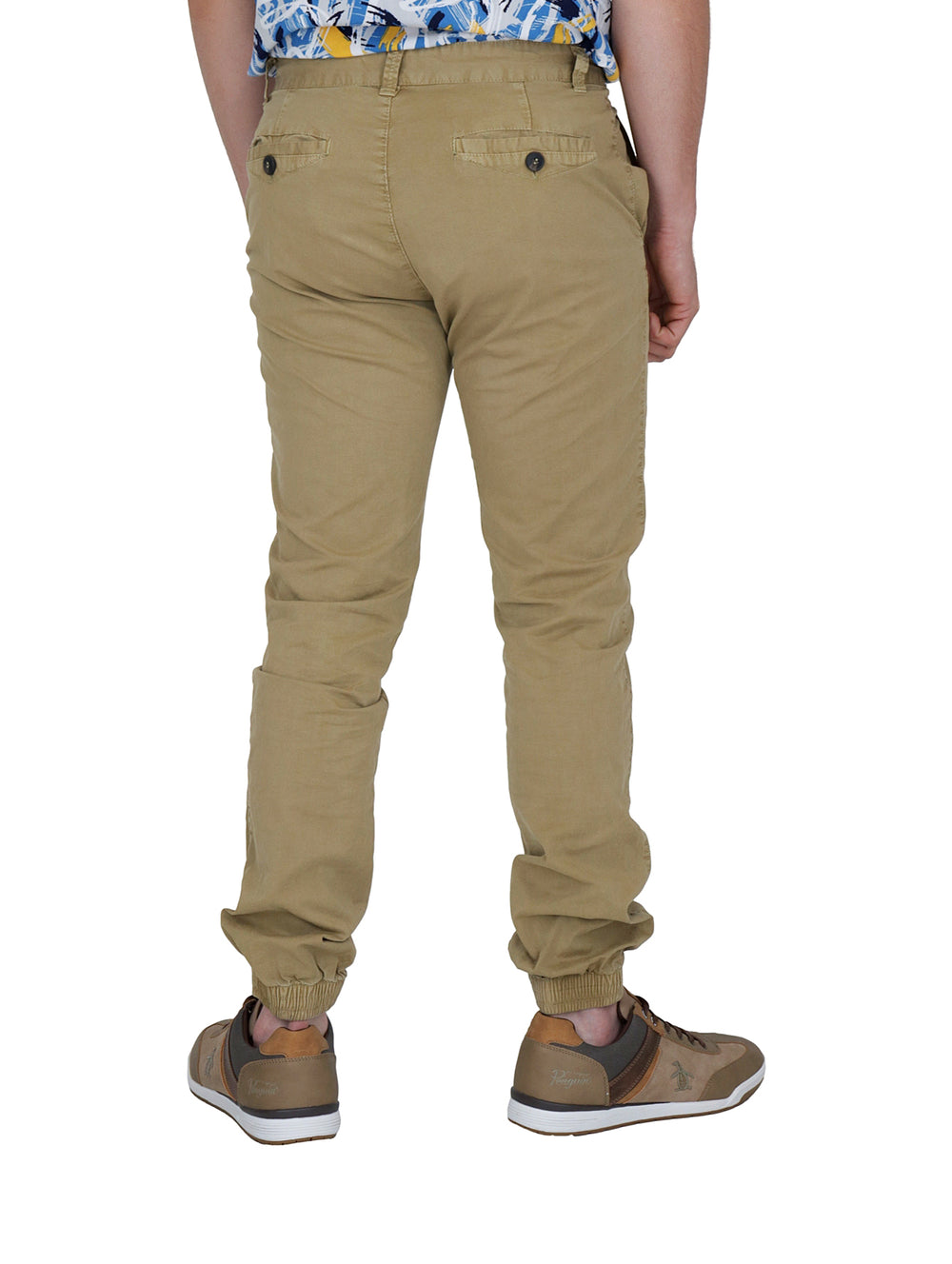 Hombre vistiendo pantalones tipo jogger color beige y calzado casual café.